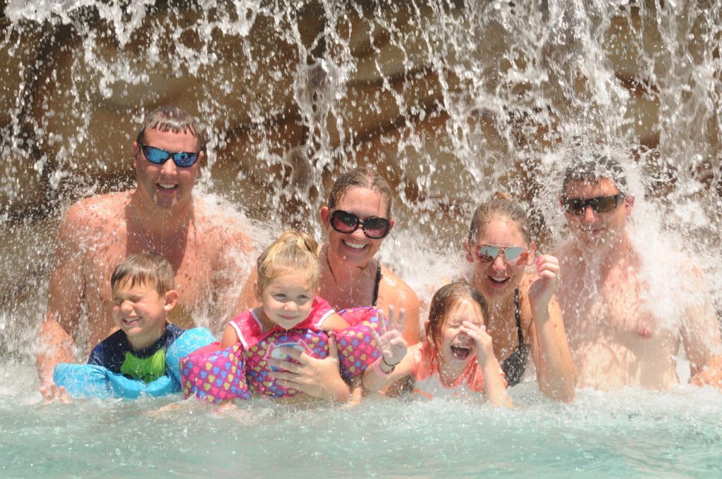 Family under waterfall at pirates cove water park