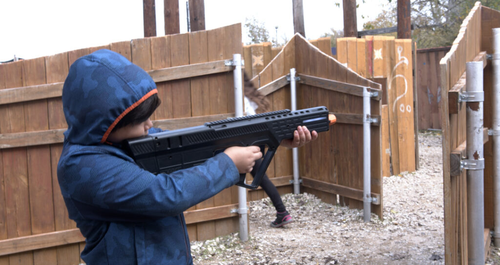 Young man shooting laser tag gun